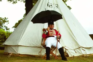 00009 Prints: Sgt. Jeff Peacock of the 68th Regiment of Light Infantry shelters from a shower during