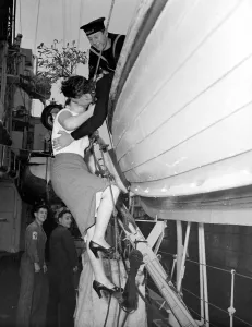00104 Prints: Shirley Cross aged 20 of Plymouth climbs a rope ladder to kiss sailor ME Dick Kemish