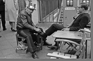 01272 Prints: A Shoe Shine goes to work on a clients shoes close to the underground station
