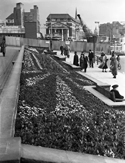 Shoppers enjoy the spring sunshine and the flower beds outside Holy Trinity Church