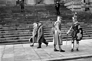 00033 Prints: Shoppers hurry past the Town Hall steps as a couple of medieval knights are locked in