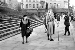 Shoppers hurry past the Town Hall steps as a couple of medieval knights are locked in
