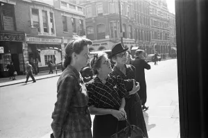 00447 Prints: Shoppers looking for a bargain read the small ads outside a Earls Court News Agents