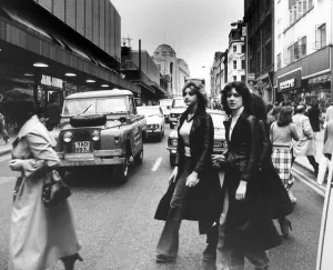 00484 Prints: Shoppers out on a Saturday afternoon dodge the traffic in Manchester City Centre