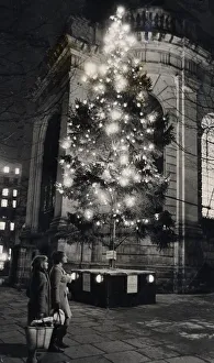 Christmas Tree Prints: Shoppers walk past the Christmas tree outside St Phillips Cathedral, Birmingham