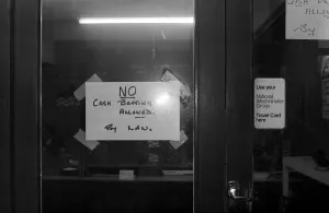 A sign on the door forbidding cash bets at a Sidney Glanz betting shop in the Isle of Man