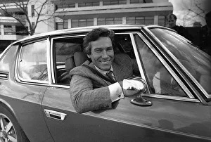 Simon Dutton Actor leans out of the window of an Aston Martin DBS March 1989