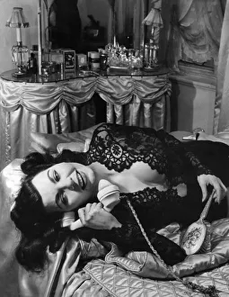 Simone Silva, french actress, answers the telephone in her boudoir