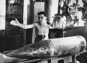 Artillery Prints: Singapore Island. A British gunner stripped to the waist for coolness deep below ground