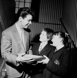 Singer Cliff Richard seen here presenting a school prize of three books to Carol