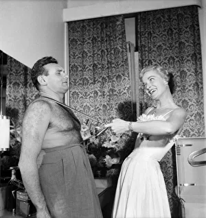 Singer Frankie Laine with wife, Nan Grey seen here pulling on his braces