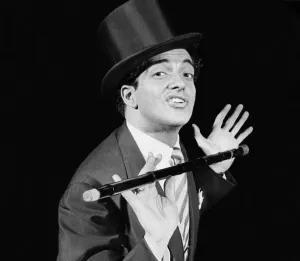 Singer Frankie Vaughan on stage performing in top hat and holding a cane