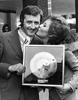 Singer Tony Christie receives a kiss from Lulu who presented him with his gold disc in