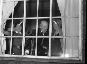 00203 Prints: Sir Winston Churchill MP stands looking out of a window with his wife