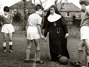 Sister Gabriel explains the art of trapping the ball to a young footballer of the St