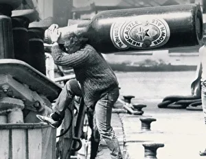 Skafti Skulason carrying a giant bottle of Newcastle brown ale aboard his trawler for his