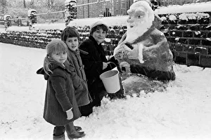 00529 Prints: Skelmanthorpe First School pupils admire a snow sculpture of Father Christmas by Karen