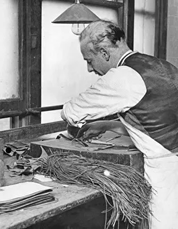 Craftsman Prints: A skilled leather cutter carries out the first stage of the manufacture of a handbag by