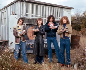 Slade holding pigeons By wooden hut shack shed Standing in the grass