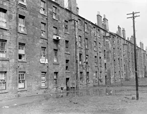 A small boy plays in the squalor outside tenement blocks in Govan, Glasgow
