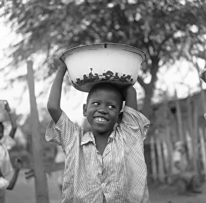 Caribbean Prints: A small boy seen here carrying water from the local standpipe home in Jonestown, Kingston