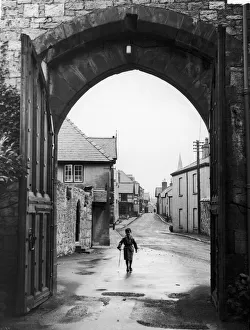 Castle Prints: A small boy walks through the archway at the entrance of Ruthin Castle Denbighshire