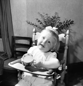 00037 Prints: Small girl enjoying a cup of tea. August 1953 D5235-002