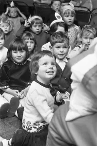 Presents Prints: A small girl looks in wonderment at Father Christmas during the Birch Copse School party
