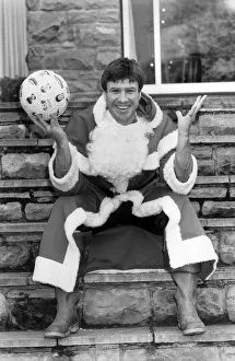 Soccer star Emlyn Hughes pictured as Santa Claus at his home in Sheffield