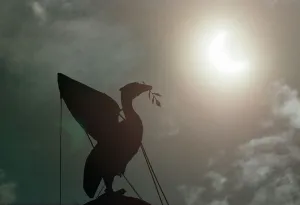The solar eclipse pictured behind the Silhouette of the Liver Bird on a tower of