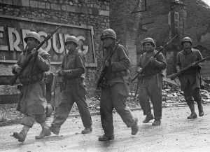 Soldiers of the US 79th Infantry Division seen here enter the fortified port of Cherbourg