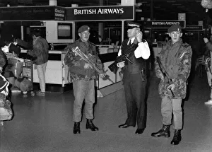 Terrorism Prints: Soldiers with machine guns tand alongside an armed police officer as security is