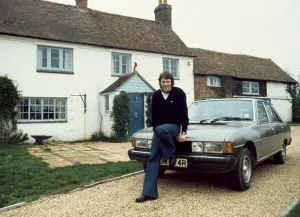 Southampton footballer Mick Channon pictured sitting on the bonnet of his car outside his
