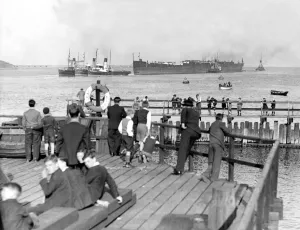 Tugs Prints: Spectators watch from the banks of the River Tyne as the hull of the Former Crack liner