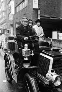 00682 Prints: Spike Milligan off for a drive in the rain in a 1901 Durkopp loaned from the Montague