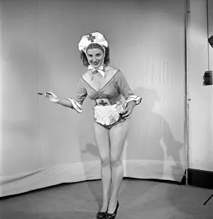 A spoonful of medicine: Woman wearing comic nurses uniform. 1959
