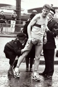 00186 Prints: Sport - London Marathon An athlete recieves attention from medics after receiving
