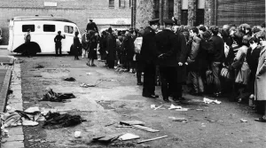 Beatlemania Prints: A St Johns Ambulance stands by and assorted litter covers the roadway in Bridport street