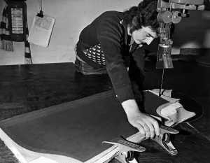 Skilled Prints: A staff member uses a 20 foot long band kinfe to cut accurately round a pattern