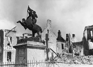 Ruins Prints: A statue of St Joan of Arc surrounded by ruins in Montebourg during Second World War