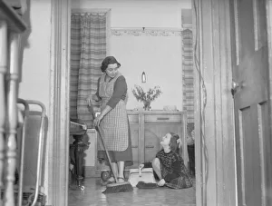 Broom Prints: Stay at home mother Mrs Mary Mackenzie seen here bing helped in her household chores by