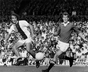 Steve Kember of Crystal Palace lays the ball off before Alan Gowling of Manchester United