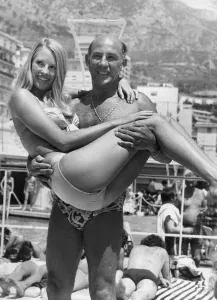 Stirling Moss carrying model Liz Hooley in Monaco - June 1973 04 / 06 / 1973