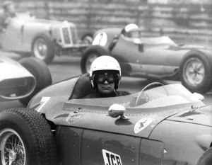 Stirling Moss sitting in Ferrari Dino racing car at Historic Car Championship Race