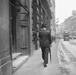 00100 Prints: Stockbroker wearing a silk hat seen here making his way to the Stock Exchange Circa 1963