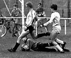 Schoolboys Prints: Stockton West End keeper Mark Woolnough dives at the feet of Michael Bates to rescue his