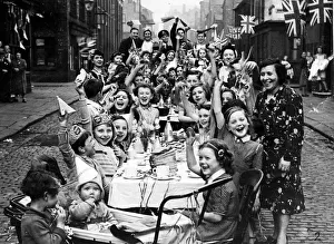Streamers and flags are waved by residents of this Manchester street when fifty children