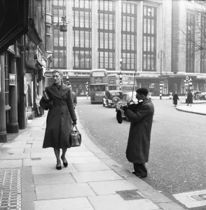 Busker Prints: A street musician serenades a passing shopper in Church Street, Kensington