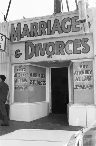 A street in Tijuana, Mexico, with neon signs for bars and quick marriages and divorces