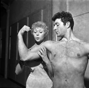 Strong man of Television Arthur Mason showing of his muscles to girlfriend Vera Day